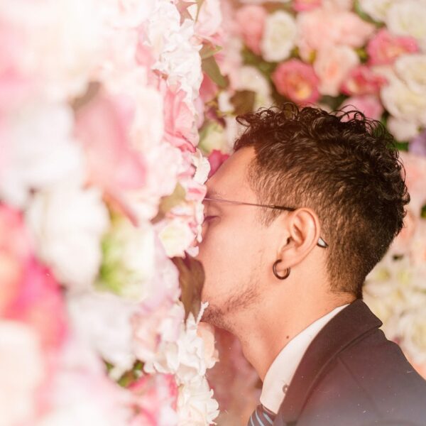 man leaning on flower wall