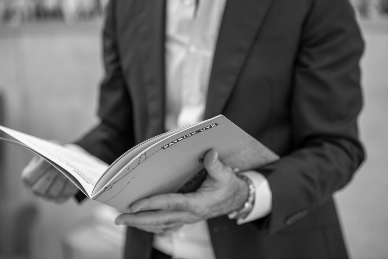 man in black suit holding book