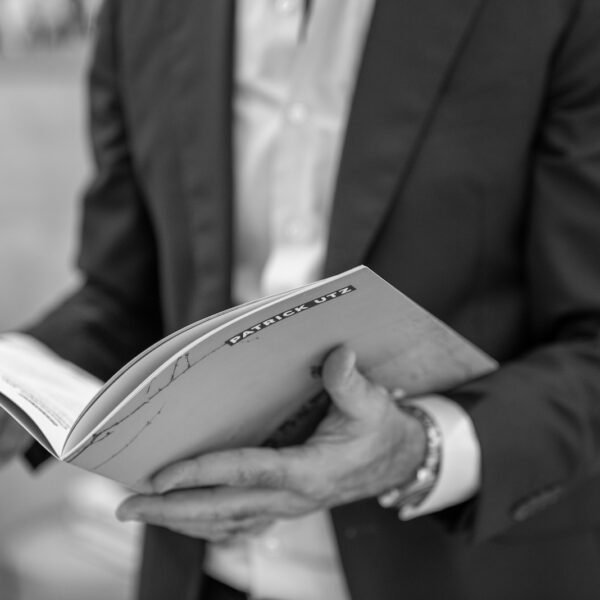 man in black suit holding book