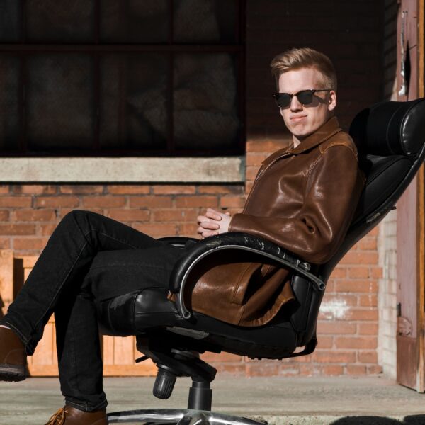 man sitting on black leather office rolling armchair